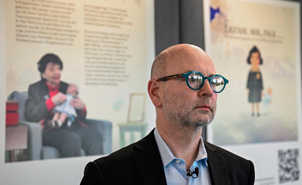 StoryFile co-founder Stephen Smith stands in front of a poster depicting Holocaust survivor Inge Auerbacher at the Meta hub in Berlin on June 6, 2023. — AFP pic