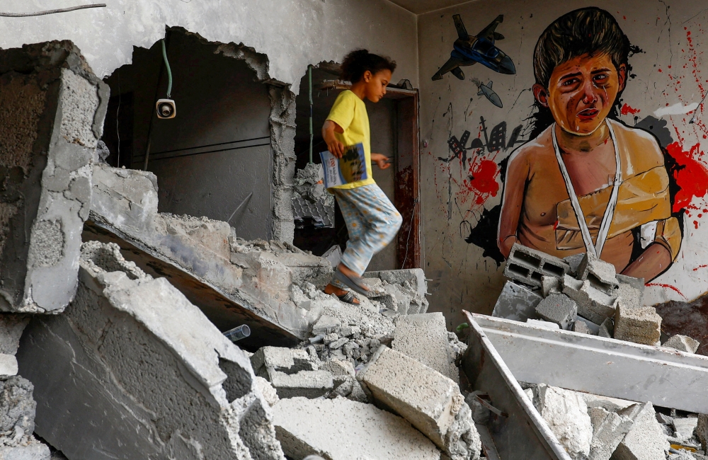 A Palestinian girl walks past a graffiti drawn by Palestinian artists on a house destroyed by Israel, in recent Israeli-Gaza fighting, in Deir Al-Balah in the central Gaza Strip June 8, 2023. — Reuters pic 