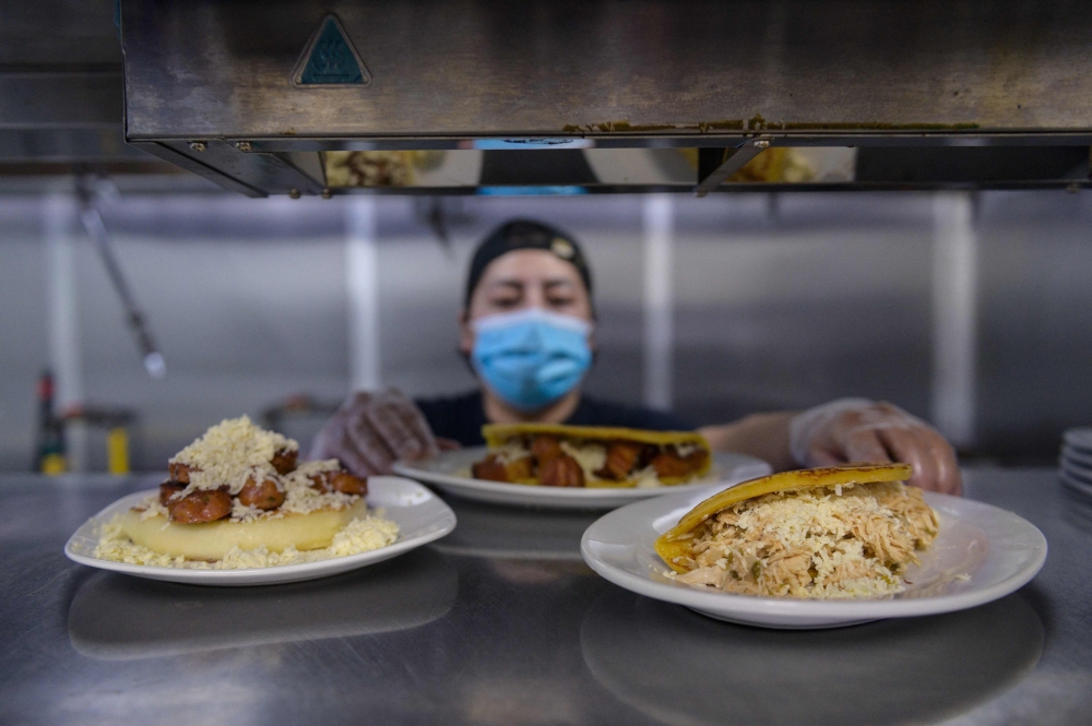 Cook Alfredo Lopez prepares arepas in the kitchen of the ‘Arepa Lady’ restaurant in the Queens borough of New York City on January 27, 2022. — AFP pic 