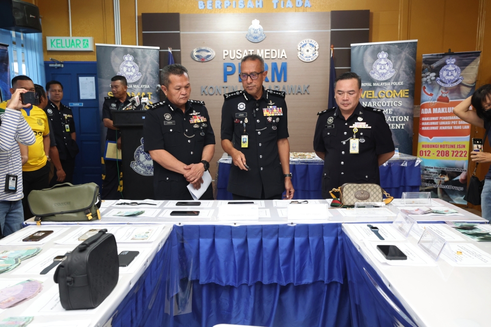 Sarawak police commissioner Datuk Mohd Azman Ahmad Sapri (centre) with the seized items seized during a press conference at the state contingent police headquarters in Kuching, June 28, 2023. — Bernama pic 