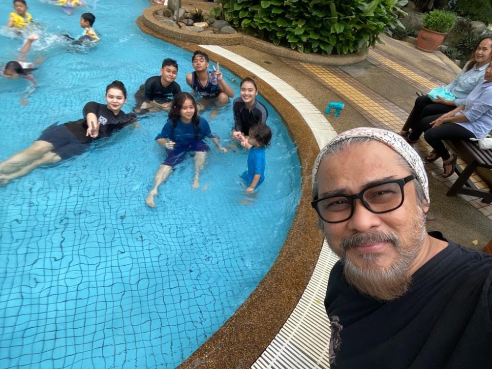 Veteran rock singer Awie posing with all his children at a hotel pool. — Picture via Facebook/Awie Pamalo  