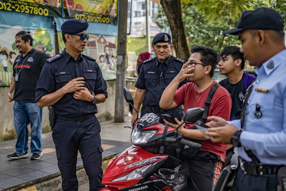 City police Chief Commissioner Datuk Mohd Shuhaily Mohd Zain (left) speaks to motorists during the ‘Respecting Traffic Regulations Operation’ in Kuala Lumpur July 3, 2023. — Picture by Firdaus Latif