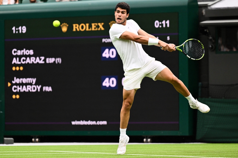 Spain’s Carlos Alcaraz returns the ball to France’s Jeremy Chardy  during their men’s singles tennis match on the second day of the 2023 Wimbledon Championships at The All England Tennis Club in Wimbledon, south-west London, on July 4, 2023. — AFP pic 