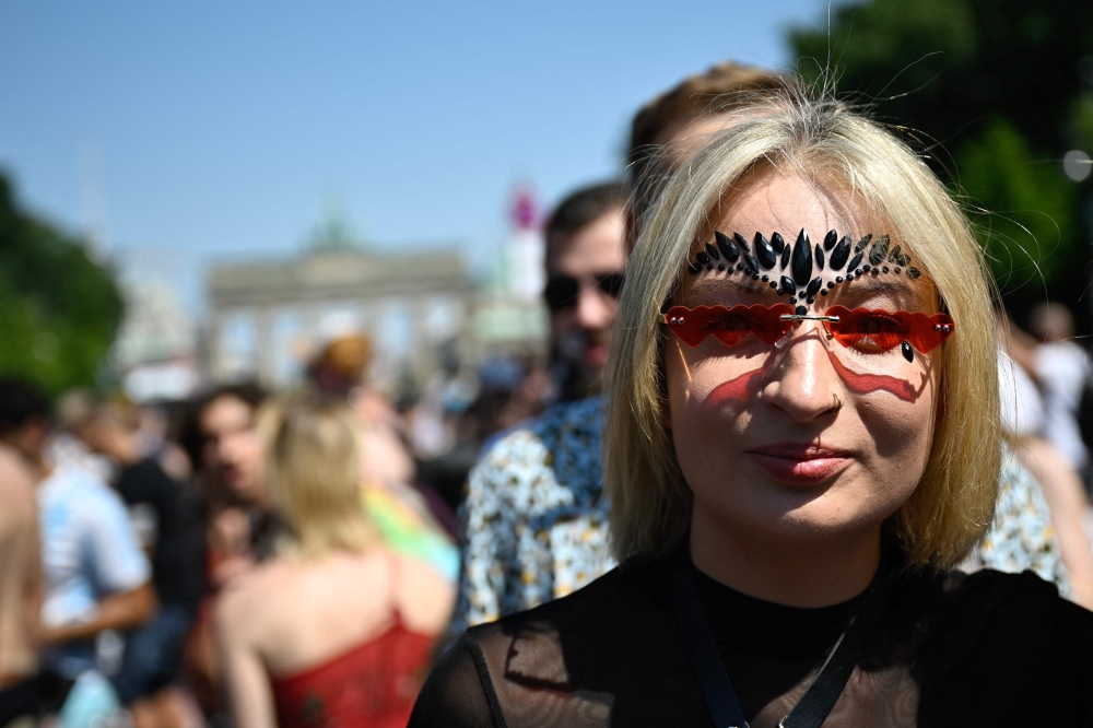 Seorang peserta meraikan semasa perarakan muzik tekno 'Rave the Planet' di Berlin 8 Julai 2023. — Gambar AFP