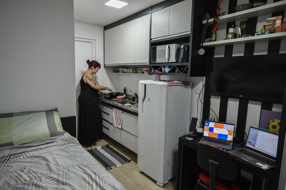 Lara Maia, memasak di pangsapuri mikronya seluas 16 meter persegi.  — Gambar AFP