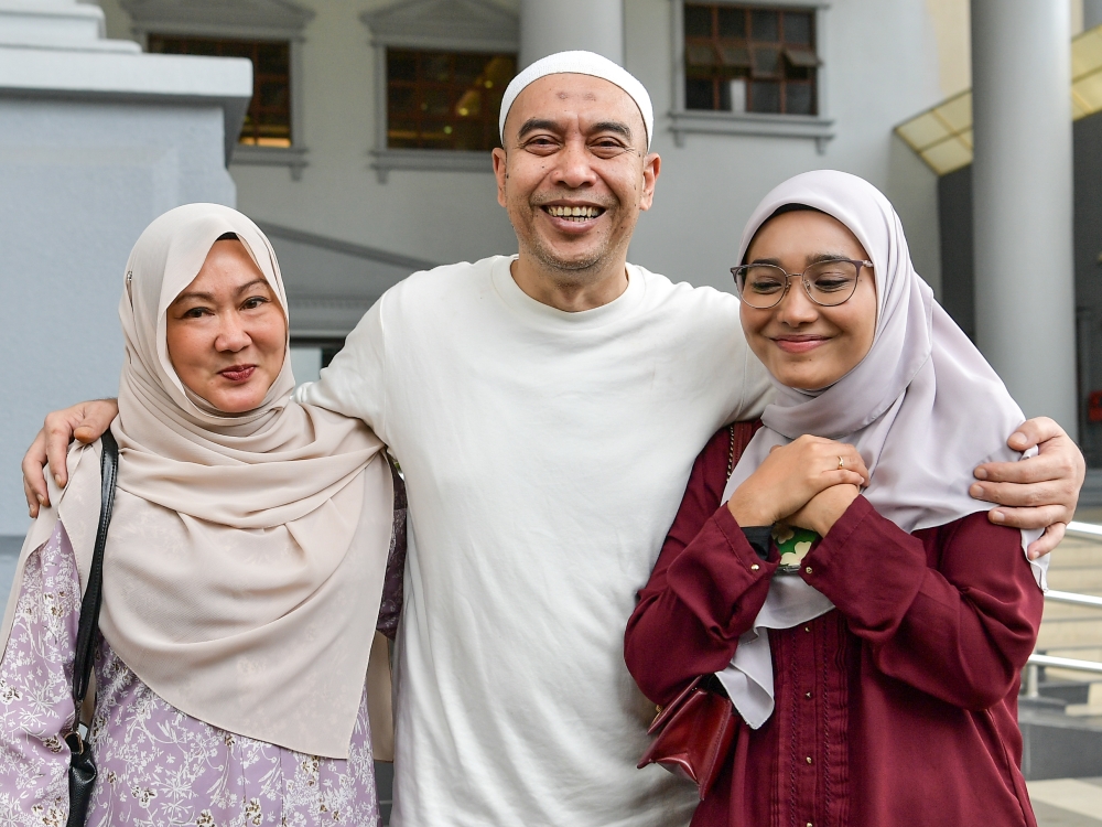 Former radio presenter Ismahalil Hamzah (centre) poses for a picture with his wife and daughter, outside the High Court in Kuala Lumpur July 17, 2023. — Bernama pic