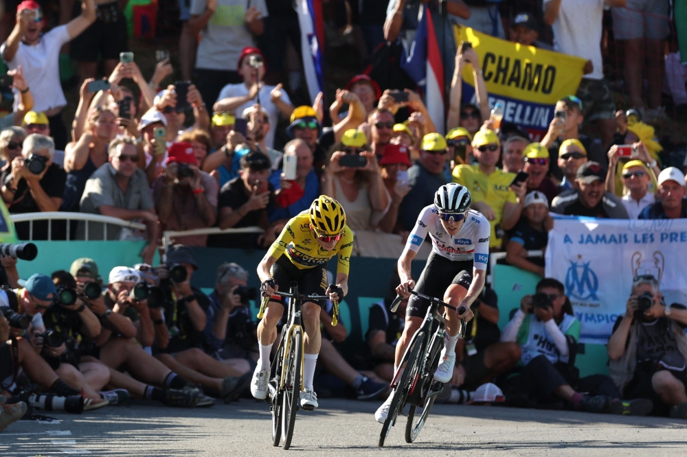 Two time former champion Tadej Pogacar (right) insisted the two hardest stages of the Tour de France were still to come and refused to concede defeat despite a crushing time trial setback yesterday. — AFP pic