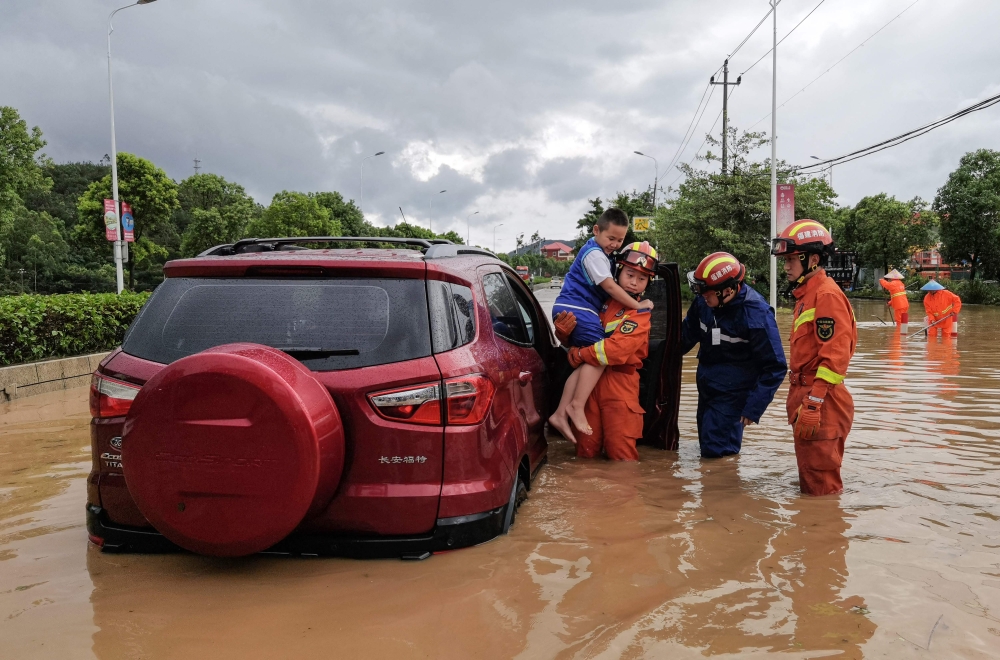 Rescuers evacuate residents in a flooded area after Typhoon Doksuri landfall in Quanzhou, in China's eastern Fujian province on July 28, 2023. ― AFP pic