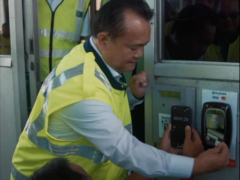 Works Minister, Alexander Nanta Linggi testing the card payment which was cleared in less than 1.3 seconds. — SoyaCincau pic