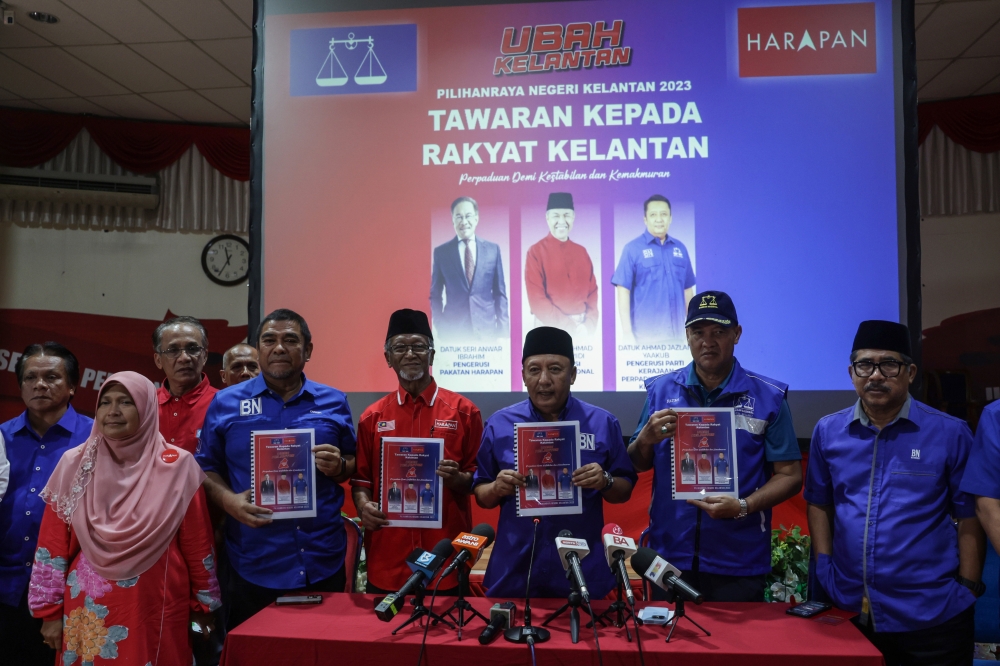 Kelantan Madani Unity Government party chairman Datuk Ahmad Jazlan Yaakub (3rd right) shows the Barisan Nasional-Pakatan Harapan manifesto during a press conference in Kota Baru August 5, 2023. — Bernama pic