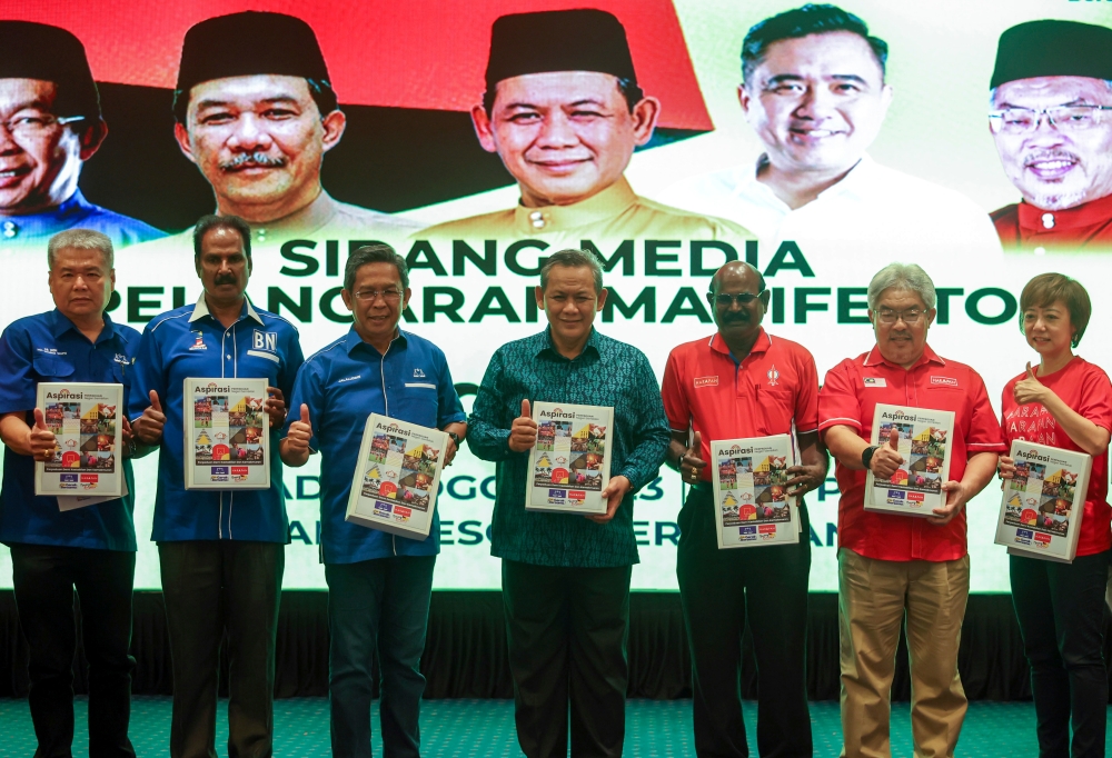 Negeri Sembilan PH chairman Datuk Seri Aminuddin Harun (4th right) and state Umno Liaison Committee chairman Datuk Seri Jalaluddin Alias (3rd left) pose with the Pakatan Harapan and Barisan Nasional manifesto during its launch in Seremban August 6, 2023. — Bernama pic