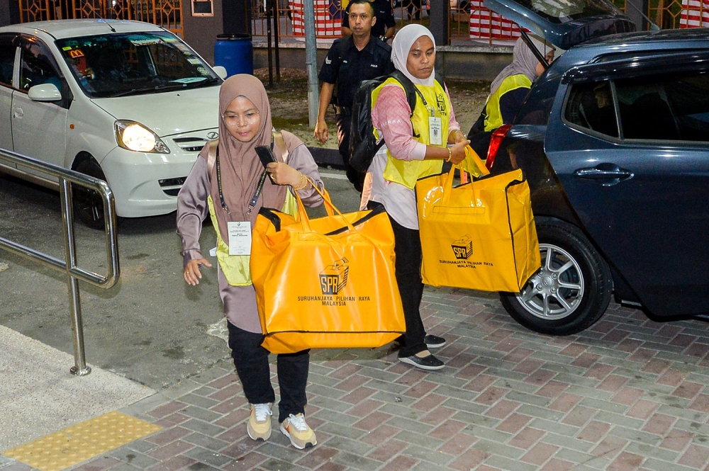 EC staff carrying ballot boxes for the state election arrive at the vote counting centre in Puchong Indah Multipurpose Hall August 12, 2023. — Picture by Miera Zulyana