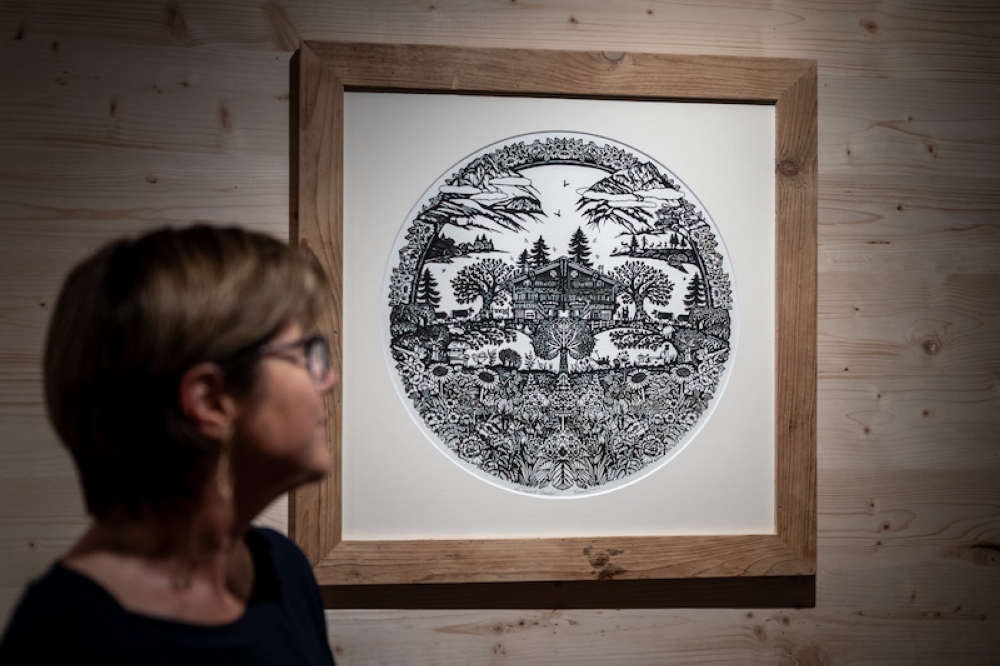 Swiss paper cutting artist Marianne Dubuis poses next to one of her works. — AFP pic