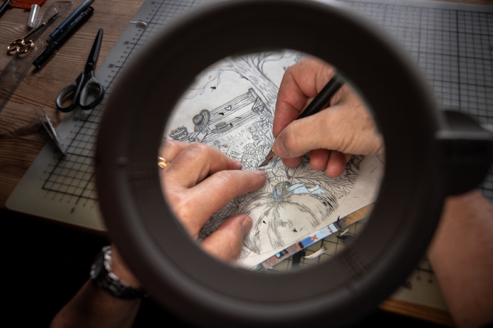 Swiss paper cutting artist Marianne Dubuis works on a piece at her home. — AFP pic