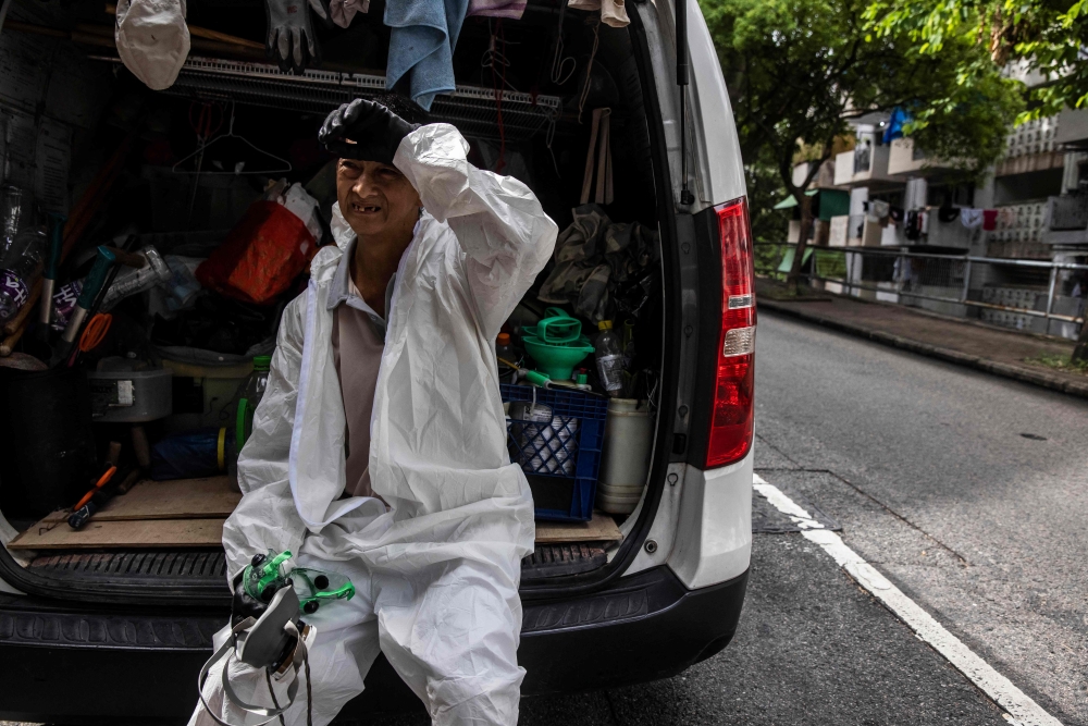 In this photo taken on August 1, 2023, elderly worker Wah rests in his personal protective equipment (PPE) after spraying pesticide in Hong Kong. — AFP pic