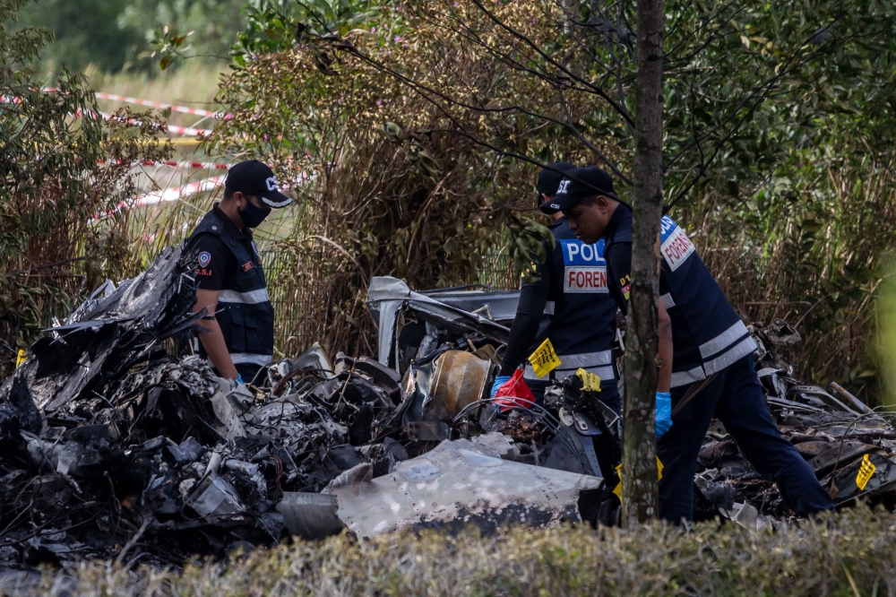 Forensic officers are pictured at the site of the plane crash in Elmina, Shah Alam August 17, 2023. — Picture by Firdaus Latif