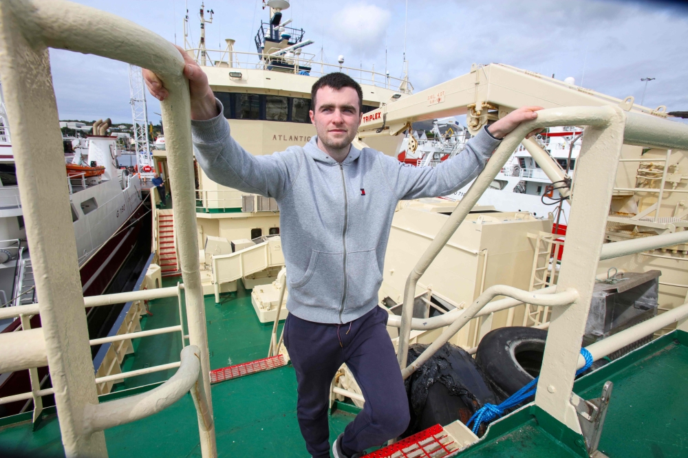 Daragh McGuinness, a deck hand on the Atlantic Challenger, poses for a photograph on the fishing vessel moored in the harbour in Killybegs, western Ireland on August 4, 2023. — AFP pic