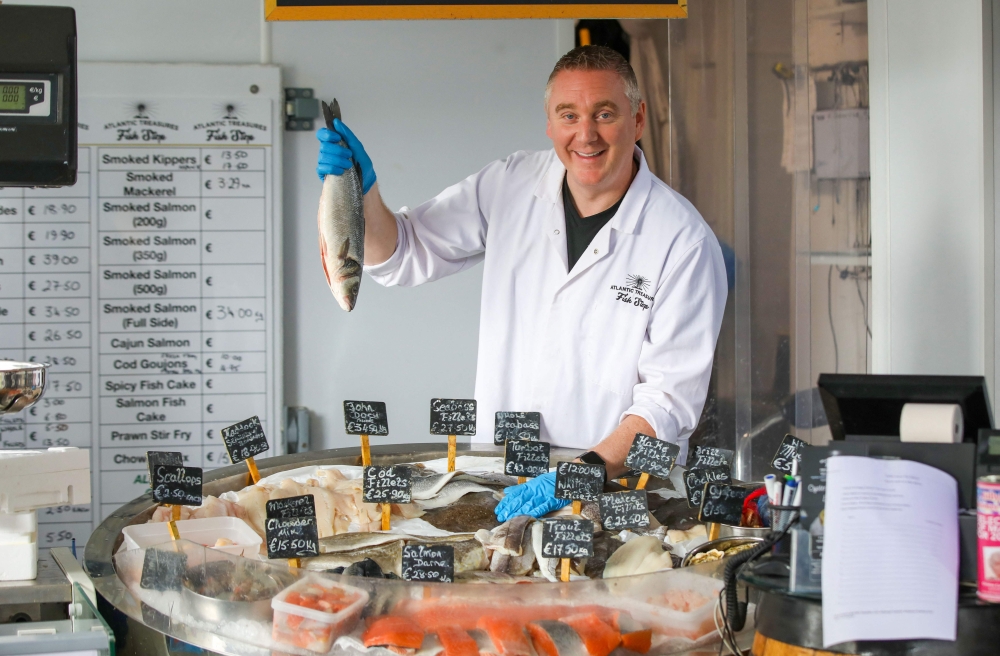 Fishmonger Michael O'Donnell poses for a photograph with some of his fish stock in Killybegs, western Ireland on August 4, 2023. — AFP pic