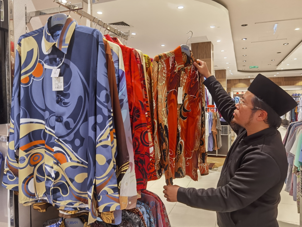 A civil servant browses through Malaysian batik clothes sold at a shopping centre in Putrajaya, August 22, 2023. — Bernama pic 