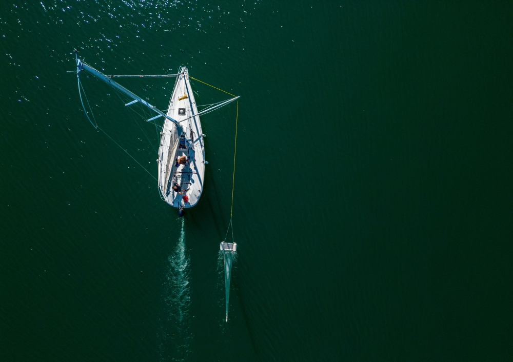 A boat of NGO Oceaneye collects plastic fragments in the water of Lake Leman in Founex, near Geneva August 21, 2023. — Reuters pic