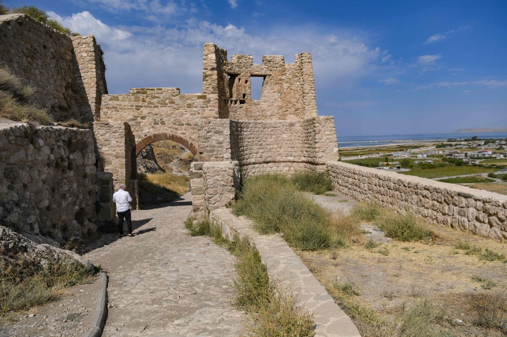 A picture taken on August 18, 2023 in Van, eastern Turkey, shows tourists visiting Van Castle, an Iron Age fortress which now stands as a ruin on the rocks. — AFP pic