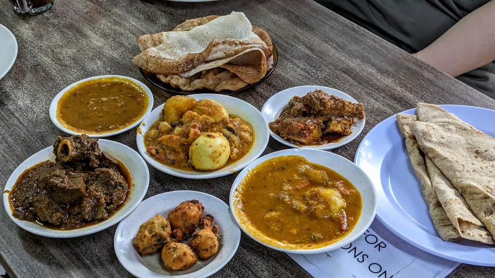 Our full spread: three 'chapati', 'thosai' and 'puri', two types of 'dhal', mutton and chicken curry and one with potatoes, chickpeas and boiled eggs.