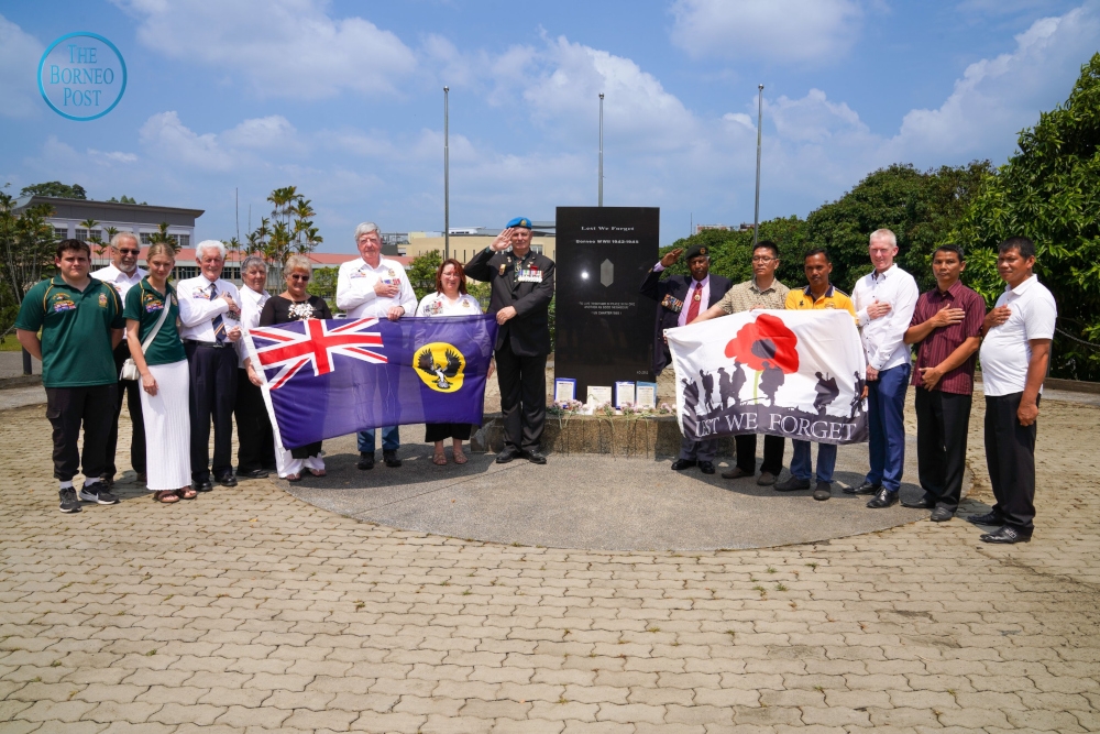 Rosenzweig (ninth left) with other veterans and their family members at the memorial. — Borneo Post pic 