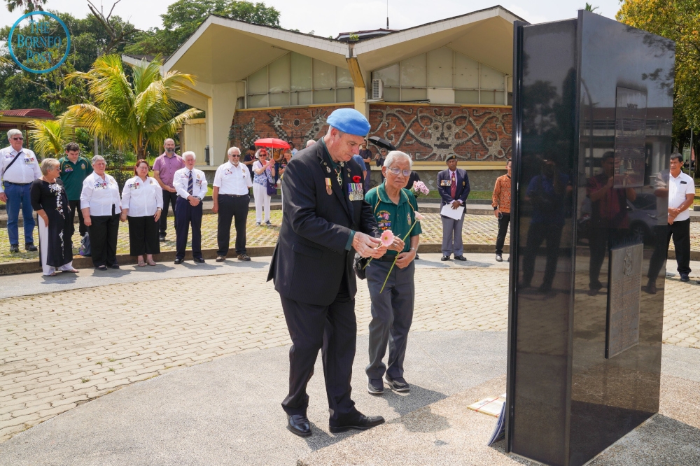 Rosenzweig places a flower at the Batu Lintang memorial accompanied by Datuk Lim Kian Hock, former heritage adviser for the Sarawak Tourism Federation. — Borneo Post pic 