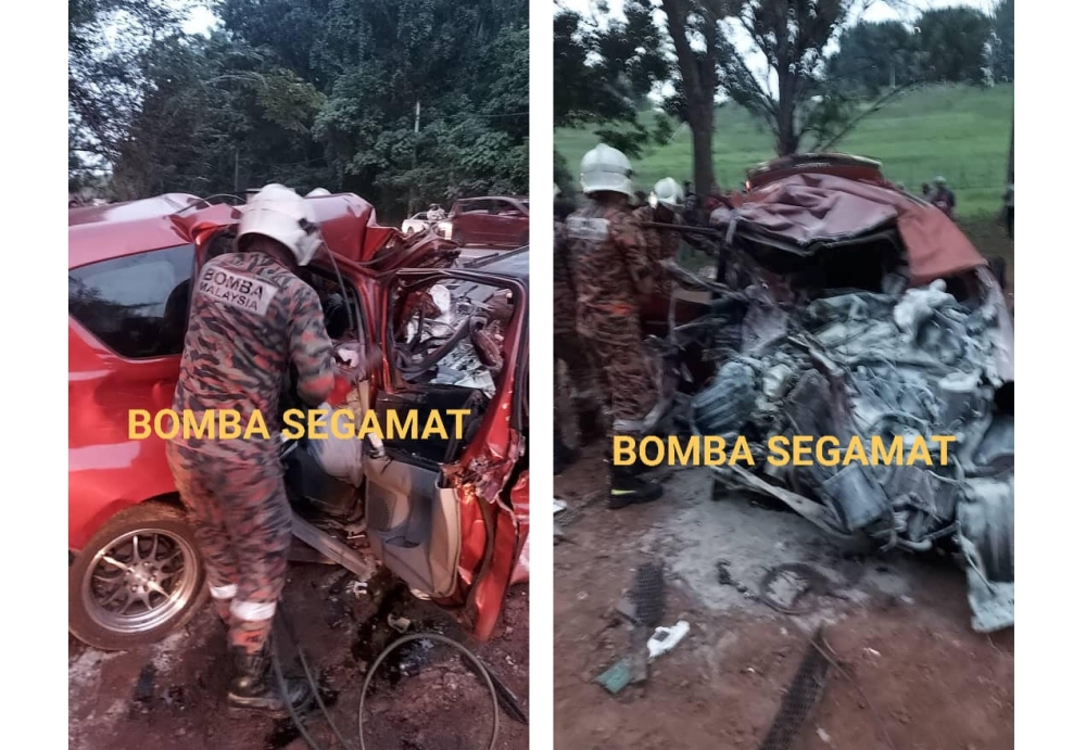 Firemen work to extract the bodies of the victims from one of the vehicles involved in the crash. — Picture via Facebook/Bandar Baru Segamat Fire and Rescue Station