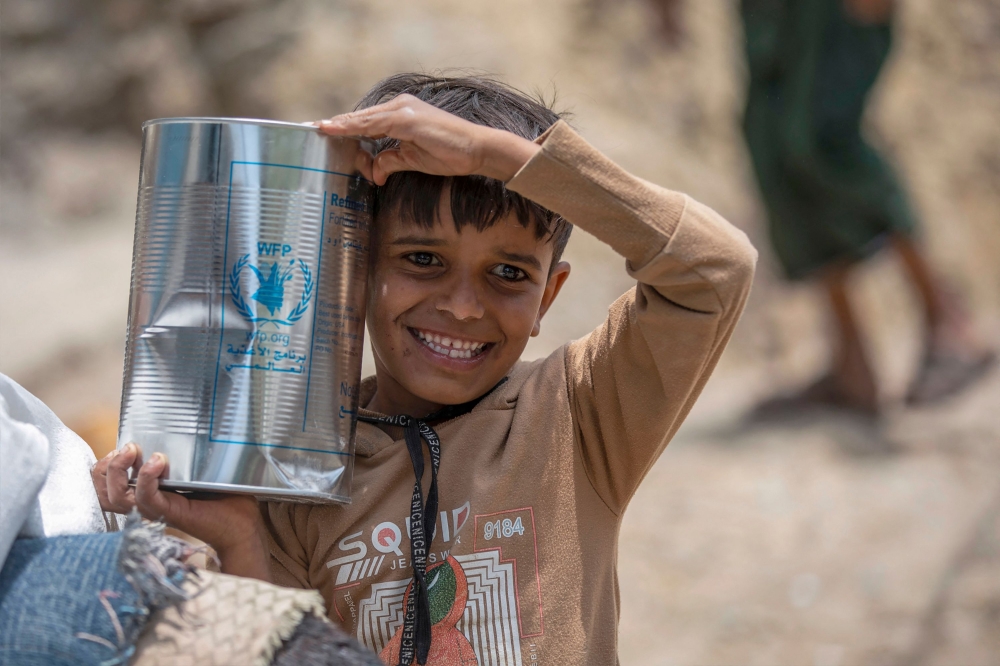 Displaced Yemenis receive humanitarian aid provided by the World Food Programme (WFP) in the city of Taiz September 11, 2023. — AFP pic