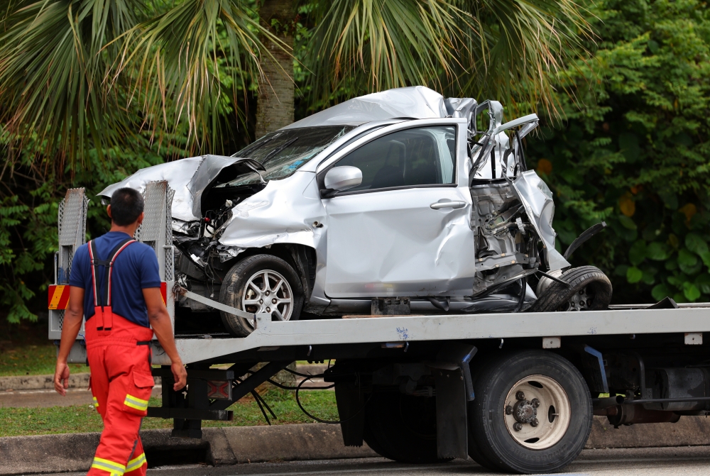 A damaged car being towed after the crash. — Bernama pic 