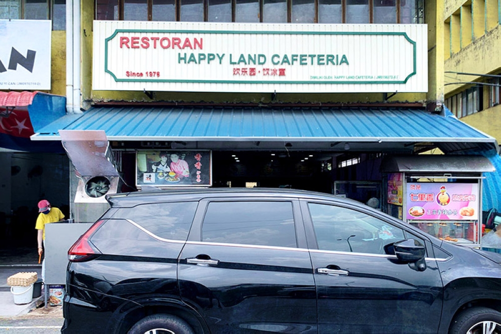 Look for a shop sign that says Happy Land Cafeteria.