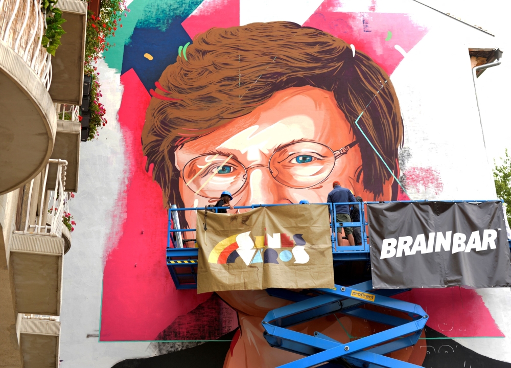 A painter makes finishing touches on a mural showing a portrait of Katalin Kariko, a Hungarian-born scientist and senior vice president at BioNTech, who laid the groundwork for the mRNA vaccines fighting COVID-19 in Budapest August 28, 2021. — Reuters pic