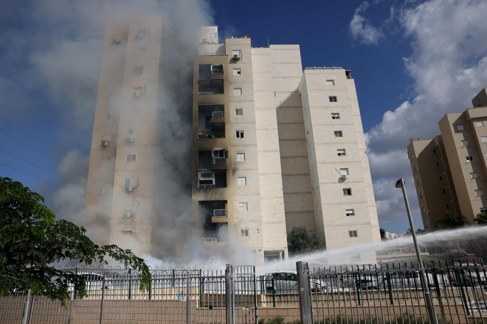 Apartments in a residential building catch fire during a rocket attack from the Gaza Strip in the southern Israeli city of Ashkelon, on October 7, 2023. — AFP pic