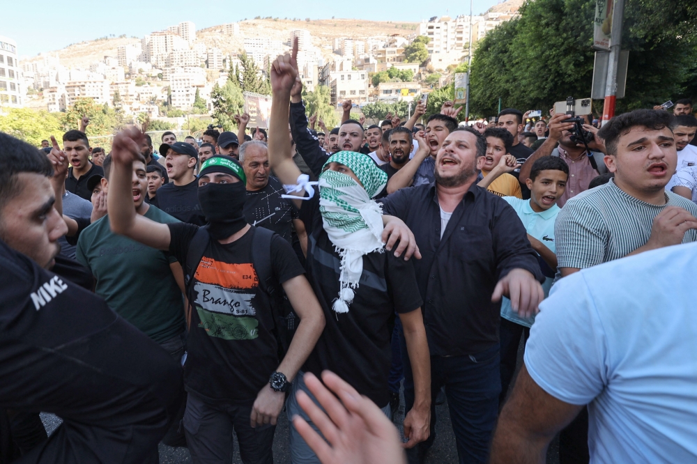 Palestinians in the West Bank city of Nablus celebrate on October 7, 2023, after fighters from the Gaza Strip infiltrated Israel, a major escalation in the Israeli-Palestinian conflict. — AFP pic