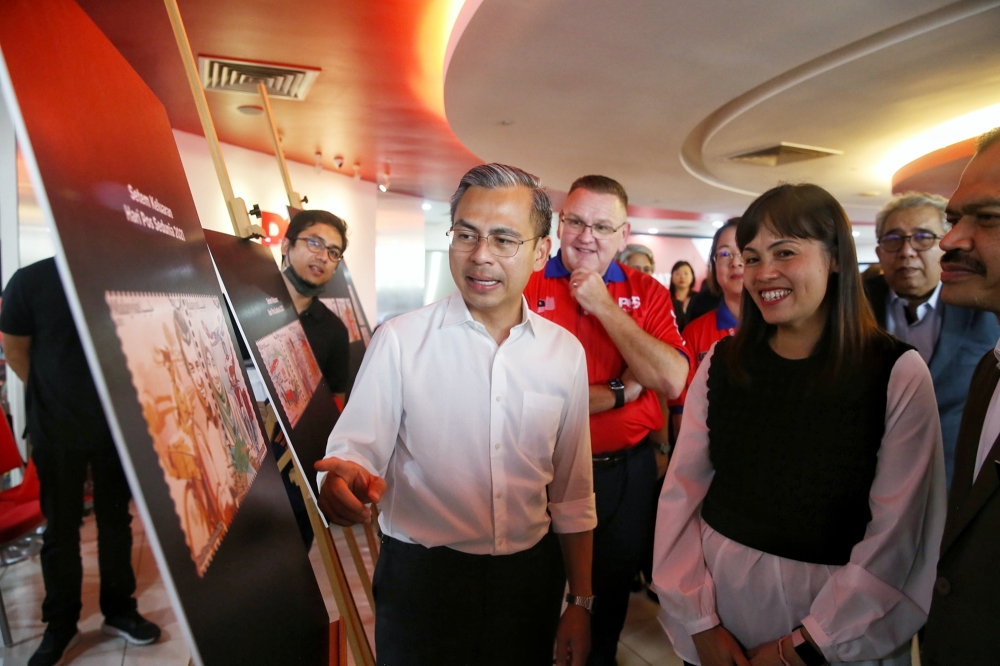 Communications and Digital Minister Fahmi Fadzil is seen here with deputy minister Teo Nie Ching and Pos Malaysia CEO Charles Brewer at the World Post Day 2023 at Dayabumi Complex. He has denied the 5G contract has been awarded to Huawei via direct negotiations. — Picture by Choo Choy May.