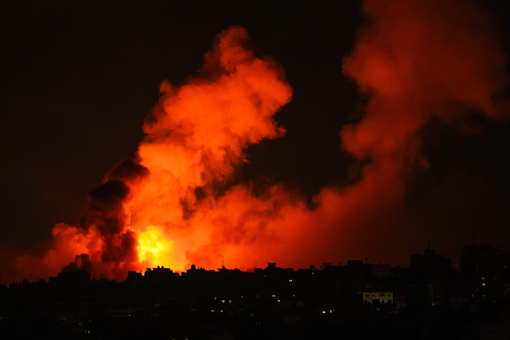 Explosions illuminate the sky during Israeli strikes on Gaza City on October 10, 2023. Israel said it recaptured Gaza border areas from Hamas as the war's death toll passed 3,000 on October 10, the fourth day of gruelling fighting since the Islamists launched a surprise attack. — AFP pic