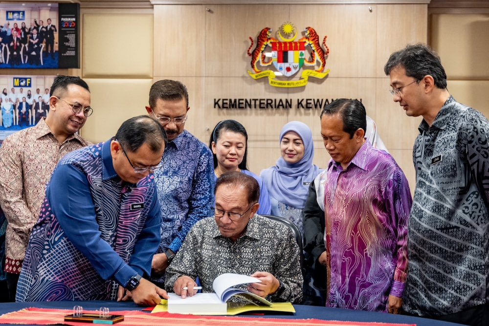 Prime Minister Datuk Seri Anwar Ibrahim with MoF personnel involved in the Budget 2024 preparations before signing the top secret document which will be tabled at Parliament today. — Picture from Facebook/Anwar Ibrahim