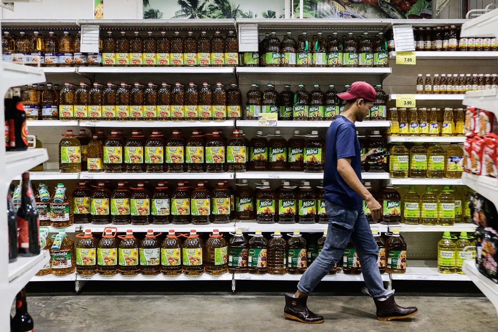 A man walks pass the cooking oil section at a supermarket in Kuala Langat, October 3, 2023. — Picture by Sayuti Zainudin 