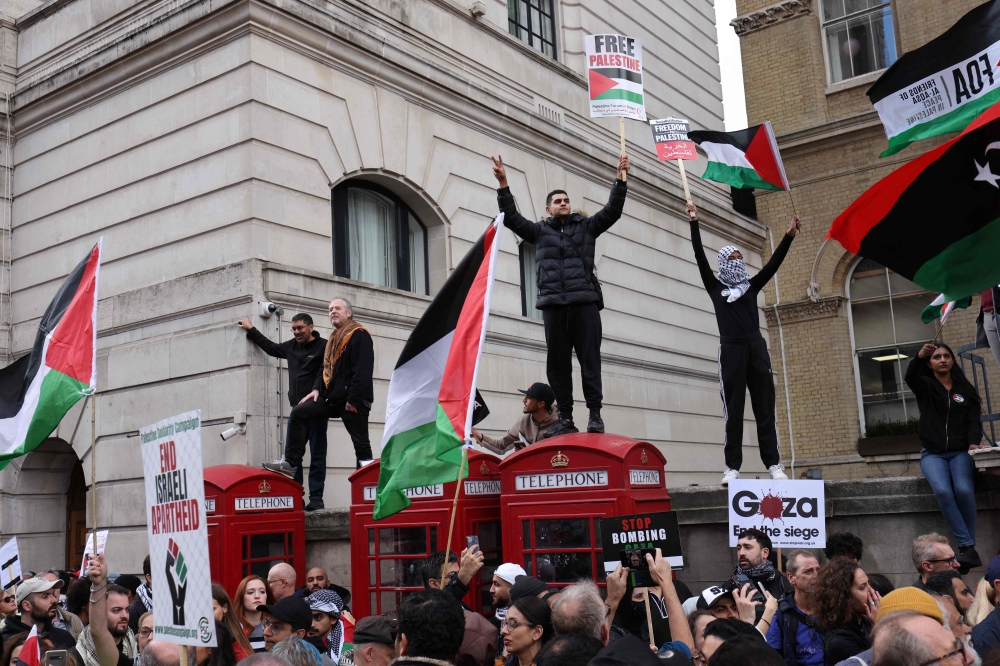 People holding placards and flags of Palestine take part in a 'March For Palestine’, part of a pro-Palestinian national demonstration, in London on October 14, 2023, organised by Palestine Solidarity Campaign, Friends of Al-Aqsa, Stop the War Coalition, Muslim Association of Britain, Palestinian Forum in Britain and CND. — AFP pic