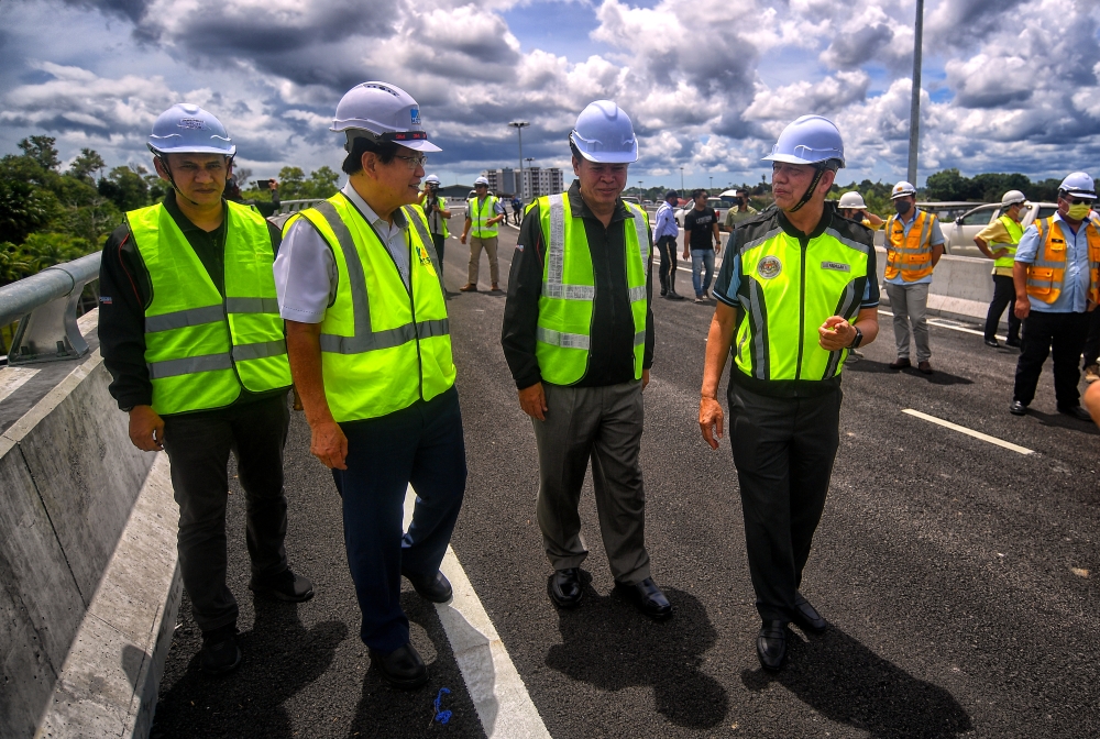 Senior Works Minister Datuk Seri Fadillah Yusof (right) talking with Sarawak Transport Minister Datuk Seri Lee Kim Shin (second left) while inspecting the construction of the Miri Airport viaduct in Miri, June 11, 2022. — Bernama pic