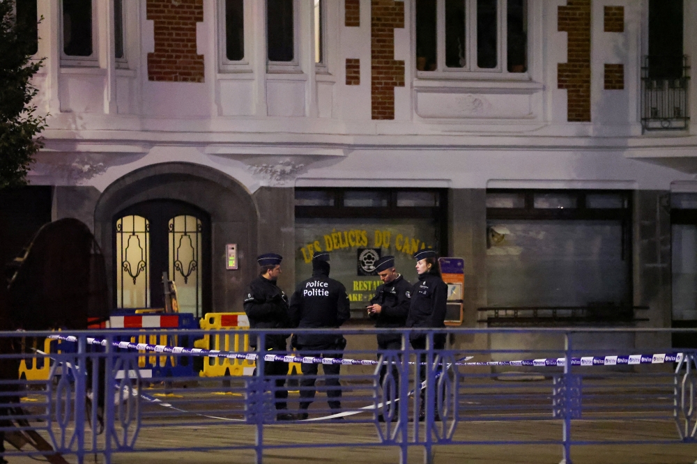 Belgian police secure the area after a shooting in Brussels. — Reuters pic