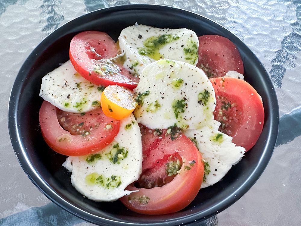 Insalata Caprese is a classic dish with fresh mozzarella, tomatoes and homemade pesto.