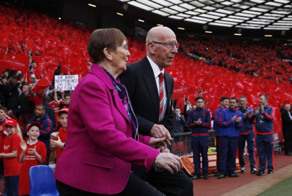 File photo of Sir Bobby Charlton and wife Norma walking out onto the pitch as fans pay tribute during the unveiling of the newly renamed South Stand as Sir Bobby Charlton Stand. - Reuters pic