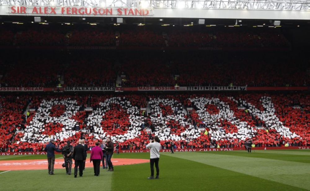 File photo of Sir Bobby Charlton and wife Norma walking out onto the pitch as fans pay tribute during the unveiling of the newly renamed South Stand as Sir Bobby Charlton Stand. - Reuters pic