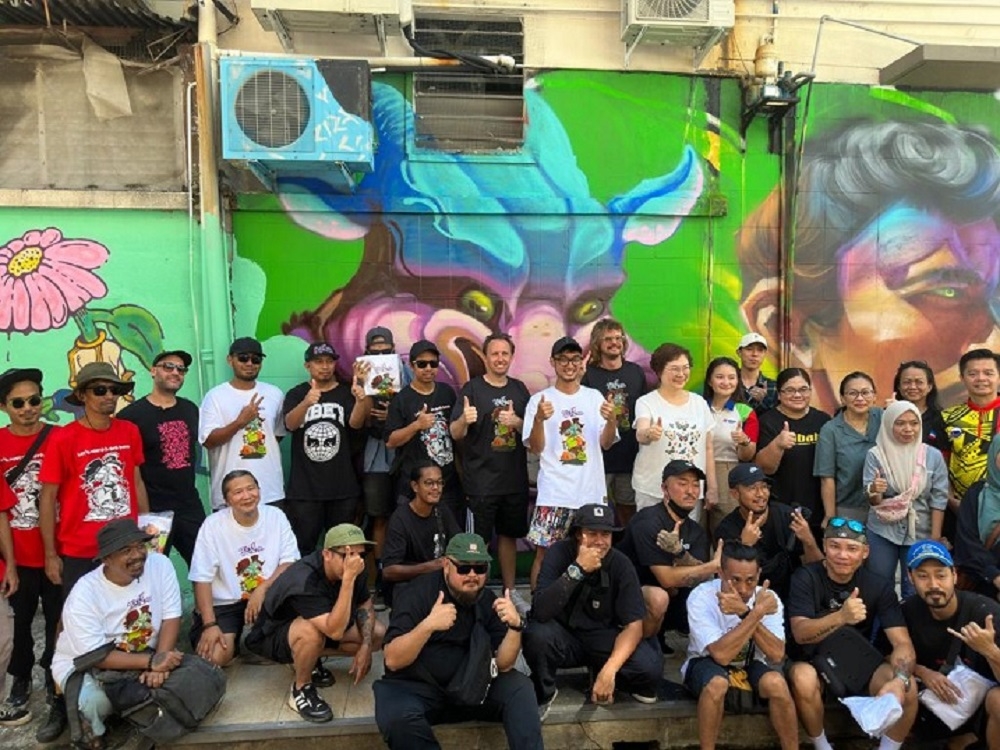 Sabah Tourism, Culture and Environment Minister Datuk Christina Liew (standing, 8th right) poses with participants of the Street Strokes community art programme. — Borneo Post pic