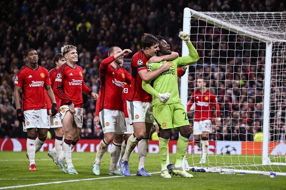 Manchester United's Cameroonian goalkeeper Andre Onana (right) celebrates with Manchester United's English defender Harry Maguire and teammates after saving a penalty kick at the end of the UEFA Champions League Group A football match against FC Copenhagen at Old Trafford, in Manchester October 24, 2023. — AFP pic