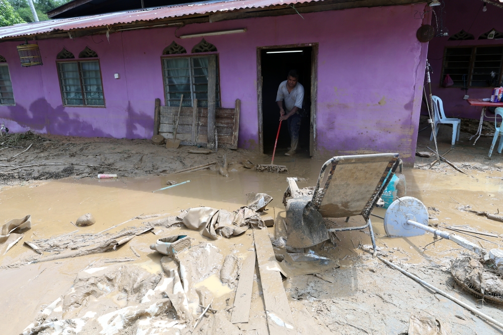 File picture of a resident of Kampung Padang Empang in Baling cleaning up mud from his home after the flood in Baling September 28, 2023. — Bernama pic 