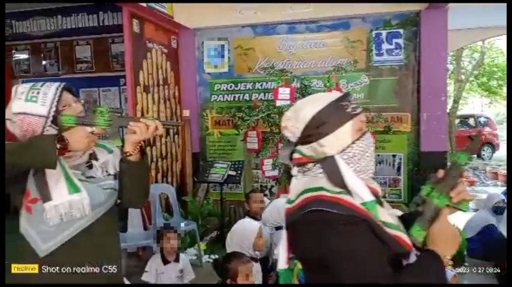 Screenshot of a video showing teachers marching to show their solidarity with Palestine in a school, with several of them brandishing toy firearms. Loke urged the Education Ministry to take strict disciplinary action against the organisers of the replica gun-toting programme and prevent any similar activity from happening again.