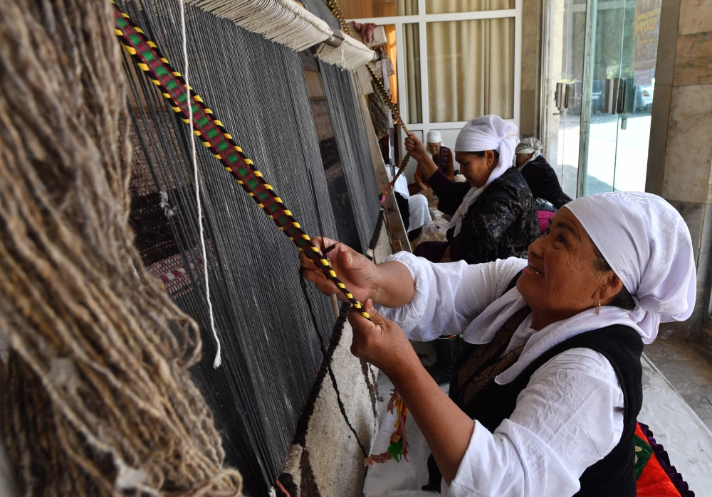 A group of older women work on weaving Shyrdaks. — AFP pic